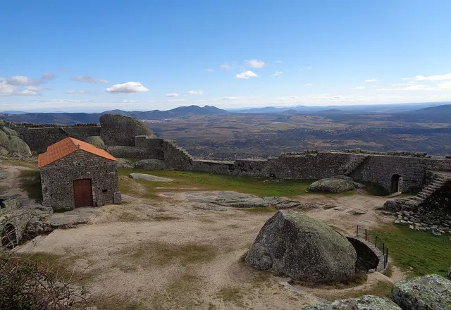 Ruínas do castelo de Monsanto entre enormes blocos de granito, com vista sobre a planície