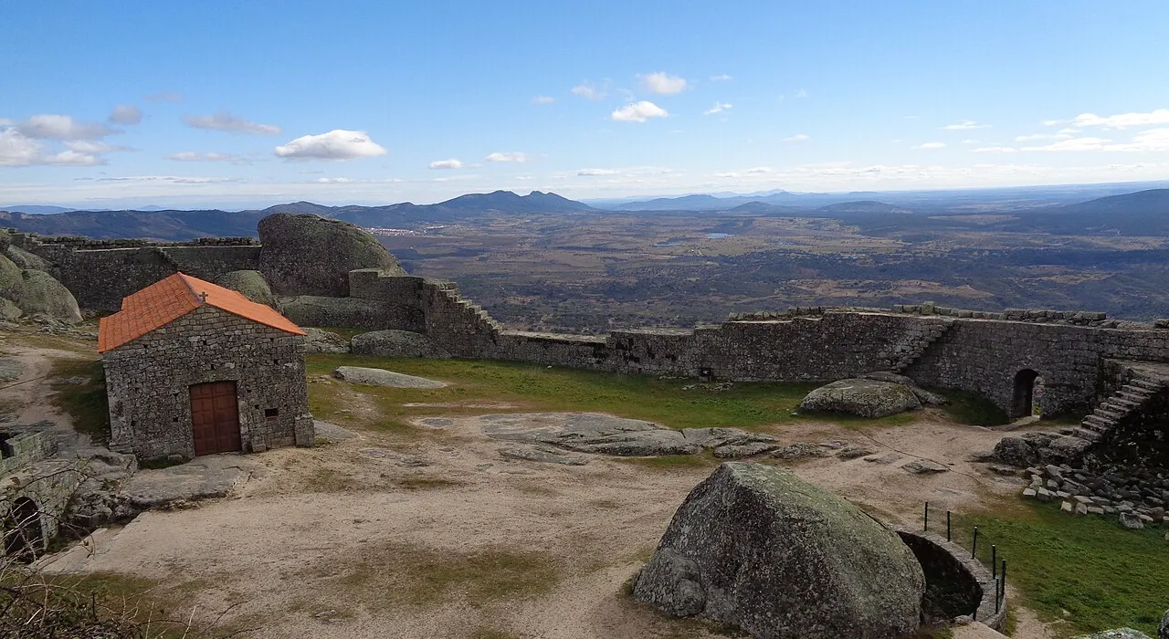 Ruínas do castelo de Monsanto entre enormes blocos de granito, com vista sobre a planície