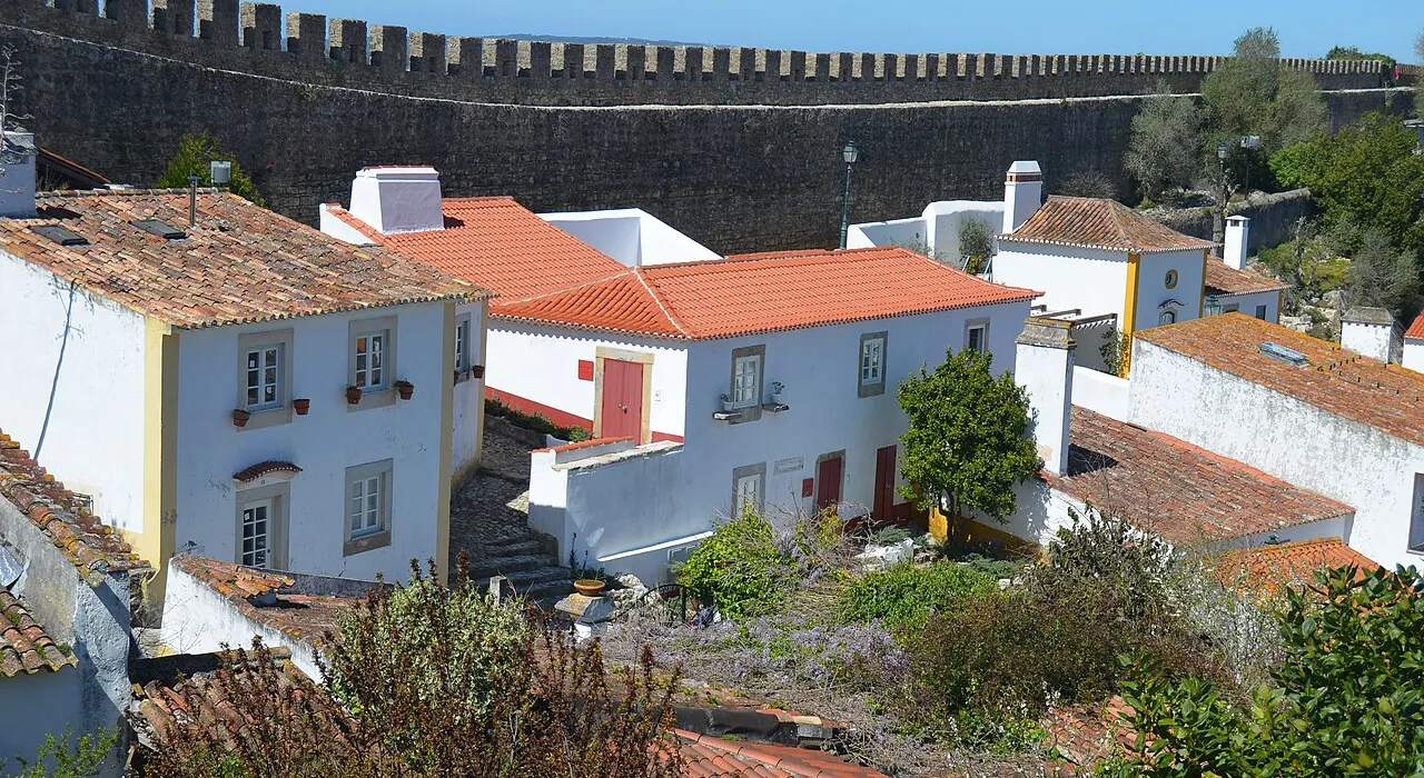 Telhados vermelhos e casas brancas de Óbidos vistos de dentro da muralha do castelo